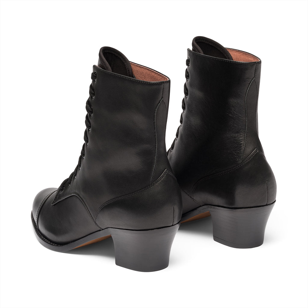 Pair of black leather boots with laces on a white background