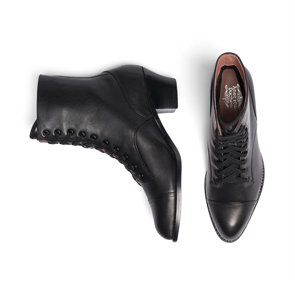 Black leather boots with detailed sole design on a white background