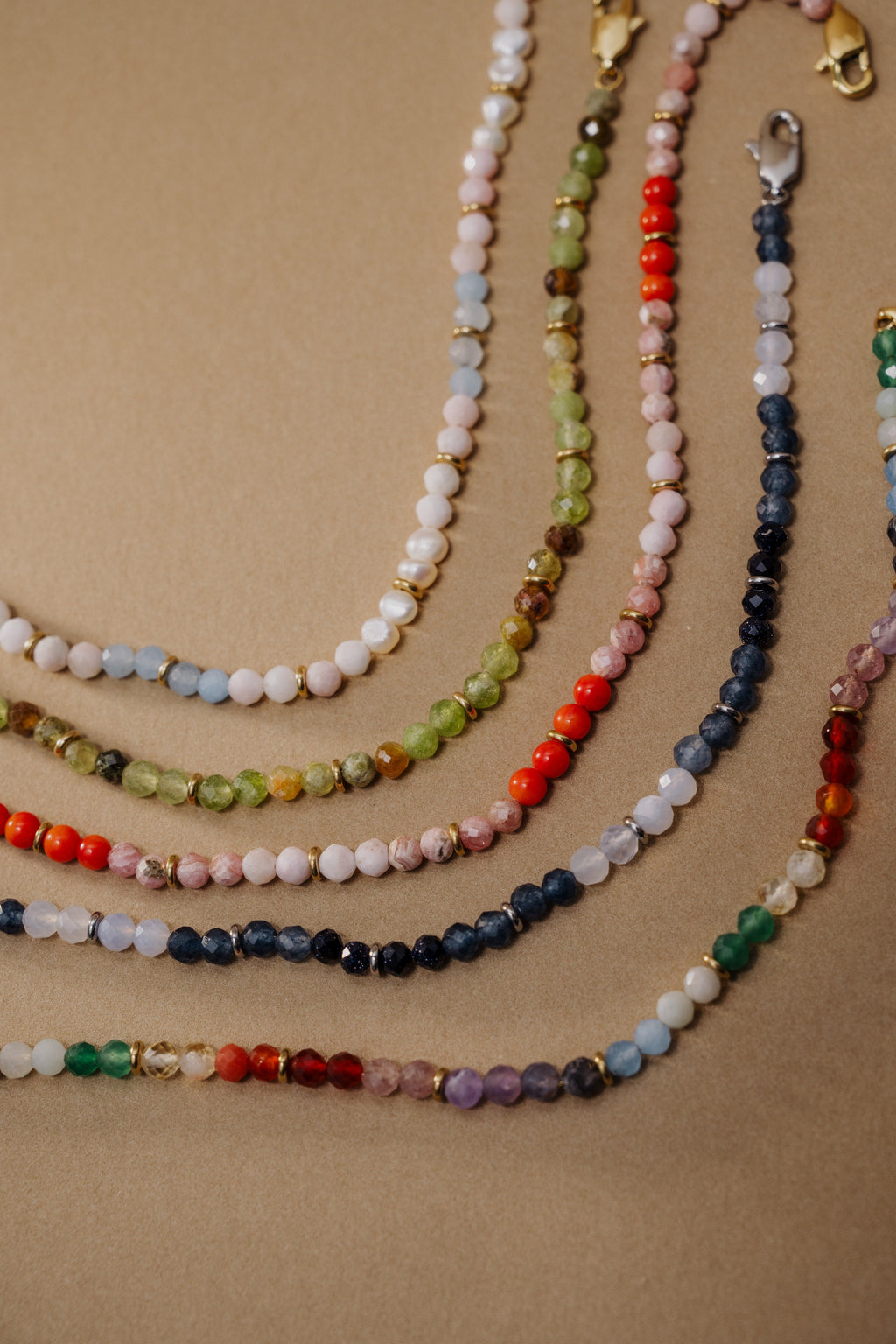 Set of multicolored beaded necklaces on a beige background