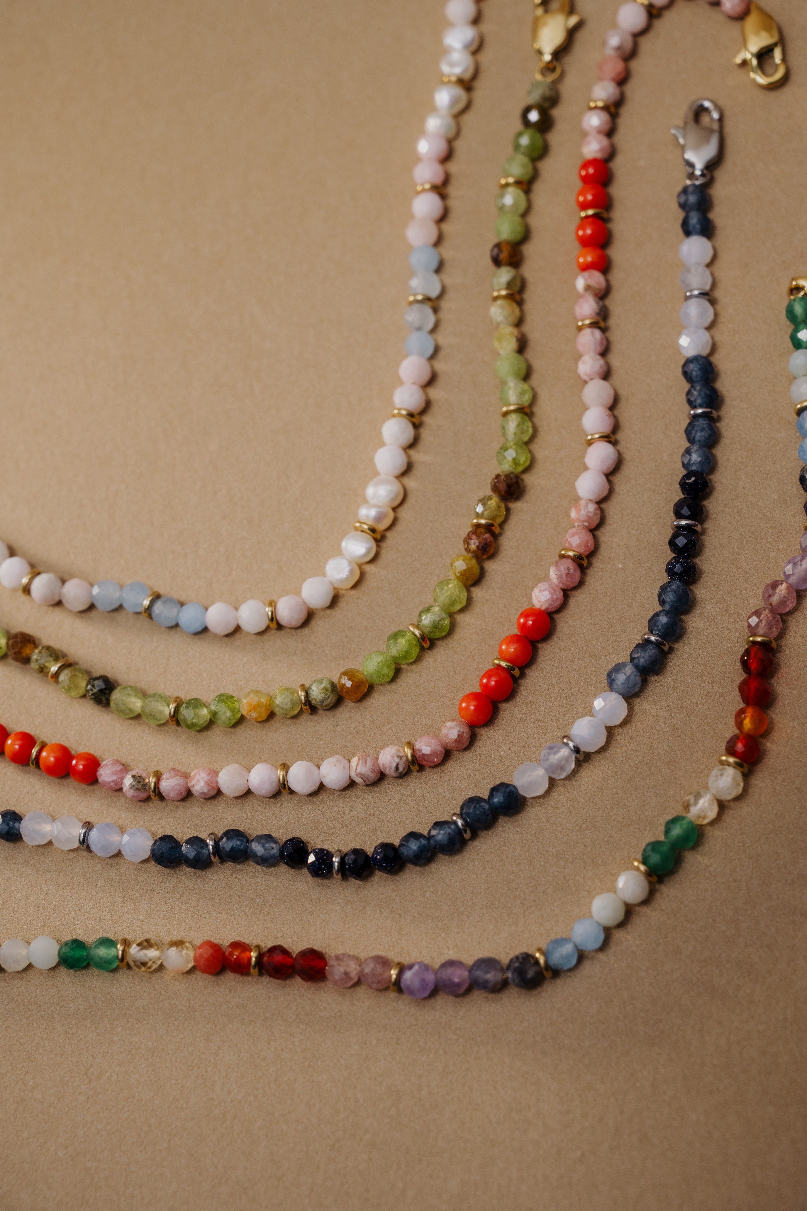 Set of multicolored beaded necklaces on a beige background