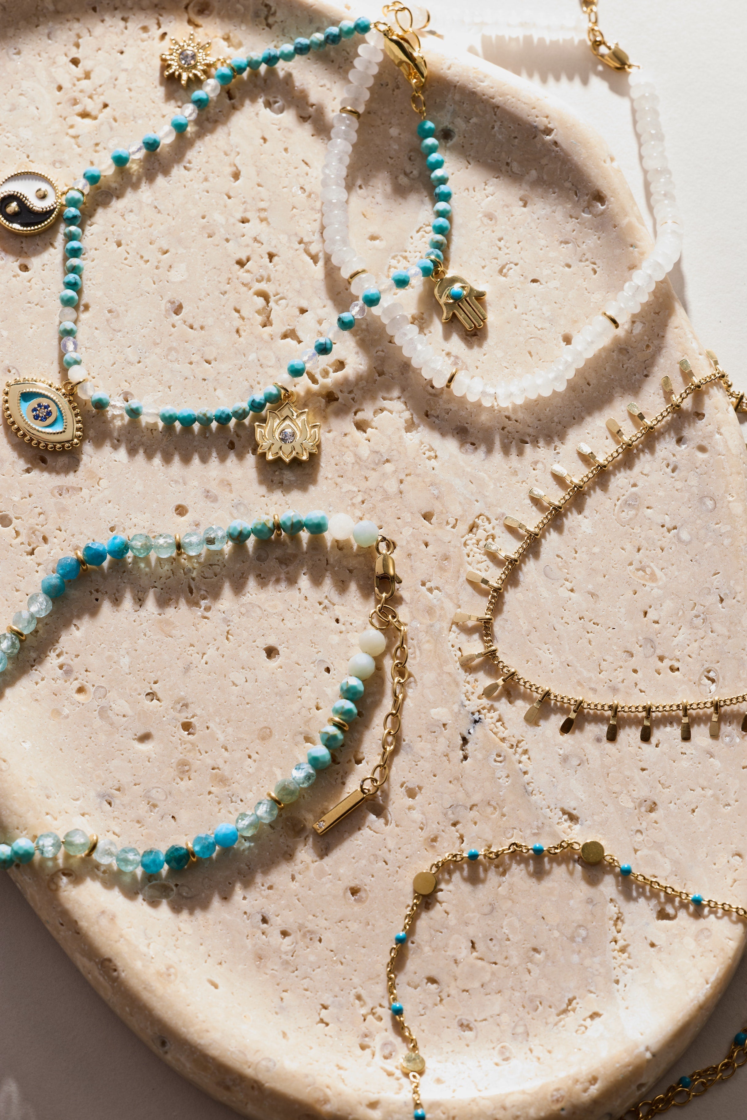 Jewelry set with necklaces and bracelets on a textured surface