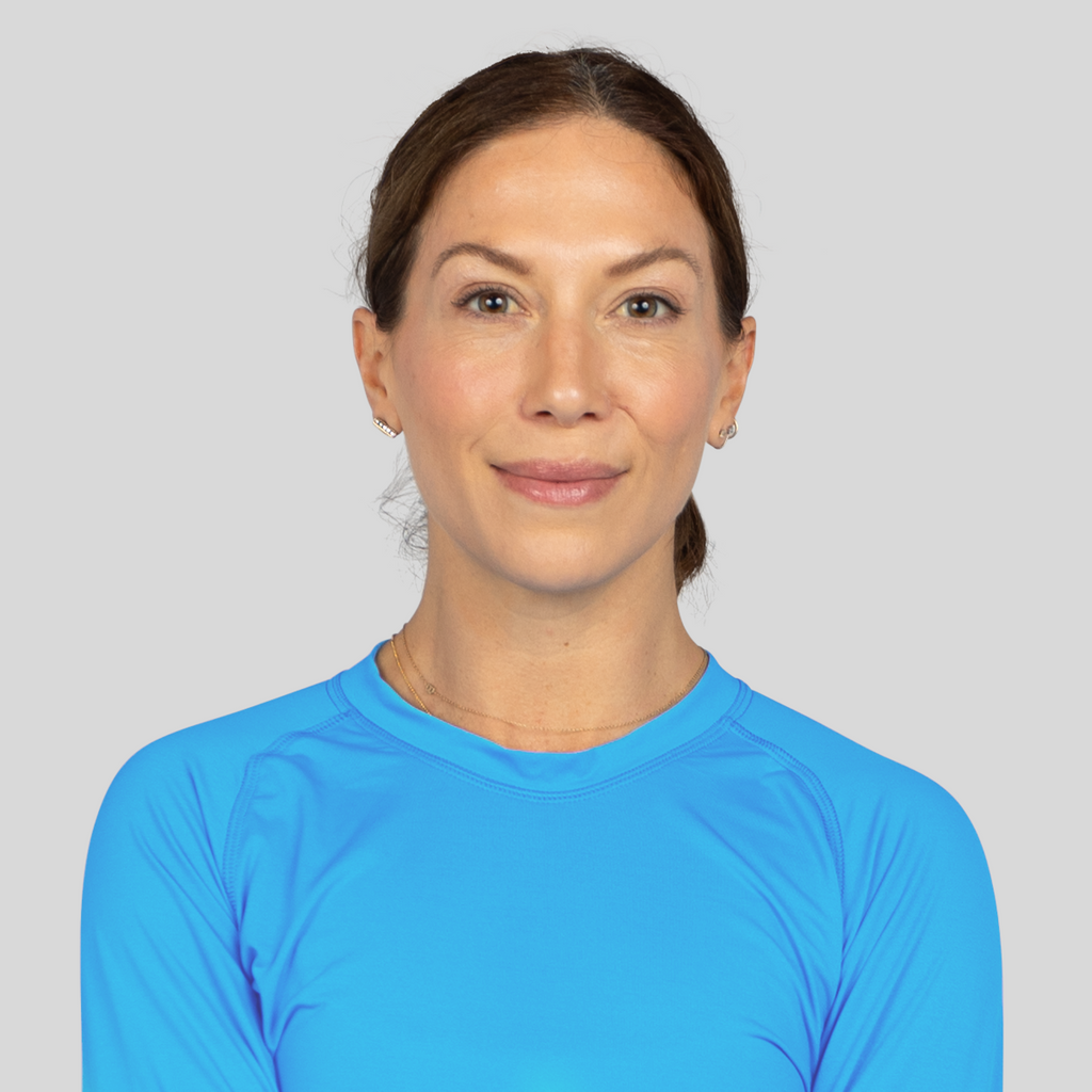 Woman wearing a blue athletic shirt against a gray background