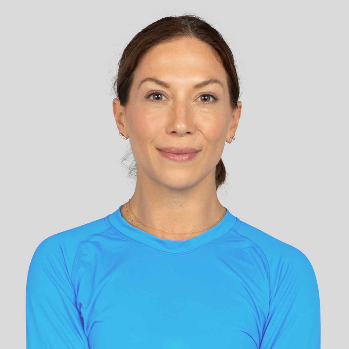 Woman wearing a blue athletic shirt against a gray background