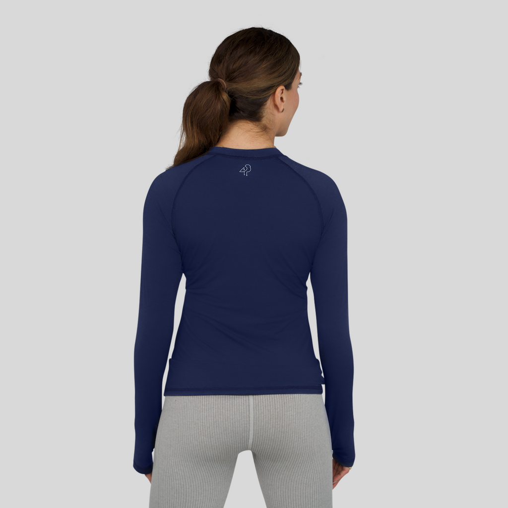 Person wearing a navy long-sleeve athletic shirt on a gray background