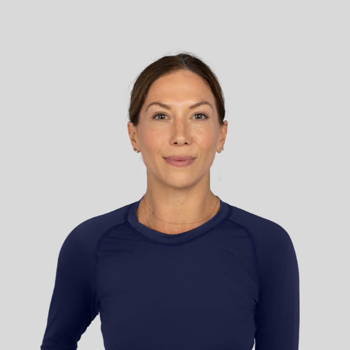Woman wearing a navy long-sleeve shirt against a light gray background