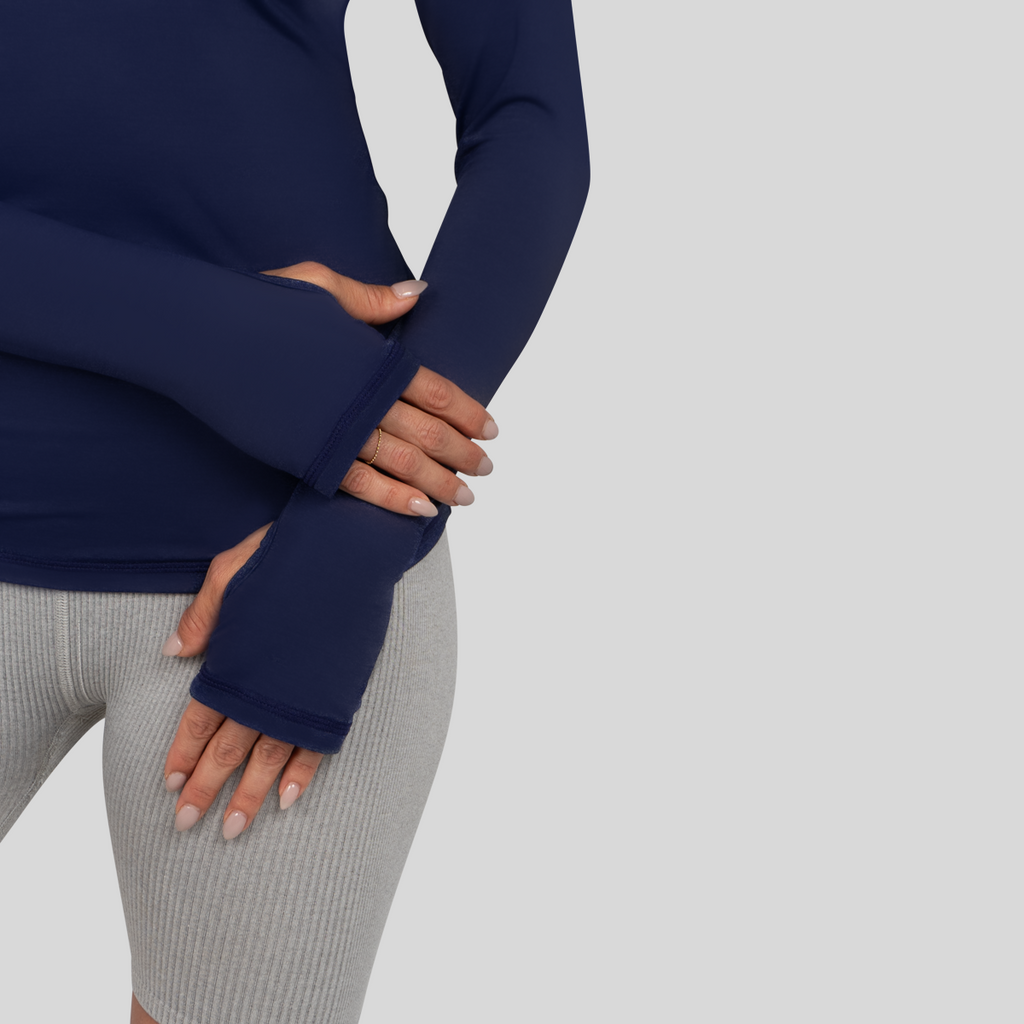 Person wearing navy blue fingerless gloves on a light gray background