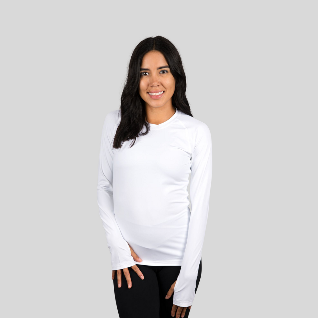 Woman wearing a white long-sleeve shirt against a gray background