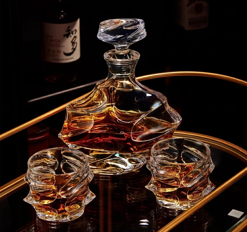 Glass whiskey decanter and two glasses on a reflective surface with a dark background