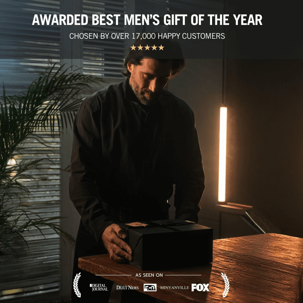 Man opening a black gift box with text about it being 'Awarded Best Men's Gift of the Year'.