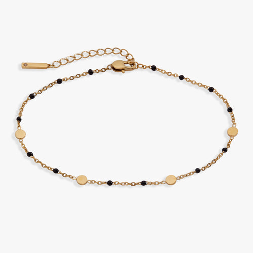 Gold bracelet with black beads on a white background