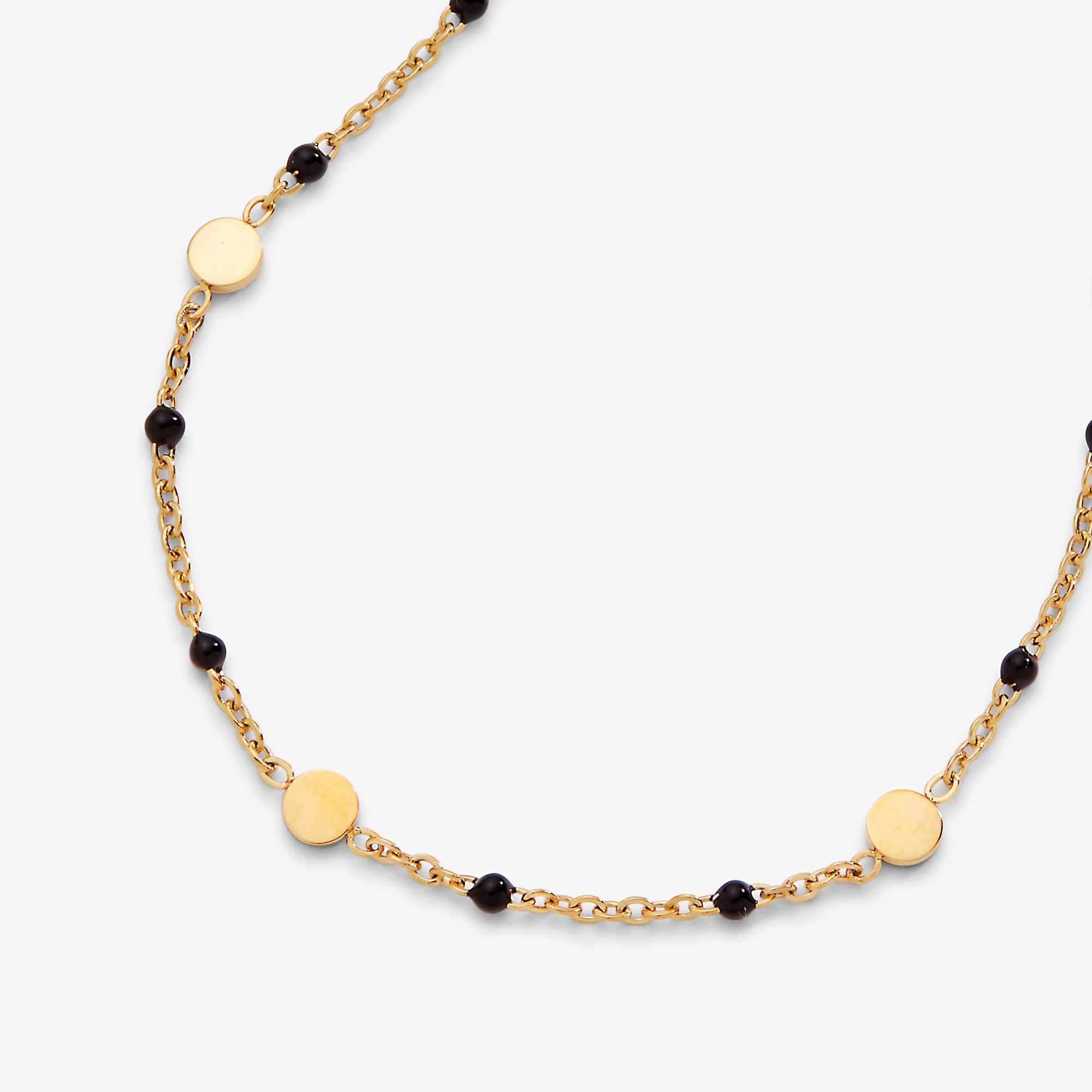 Gold necklace with black beads on a white background