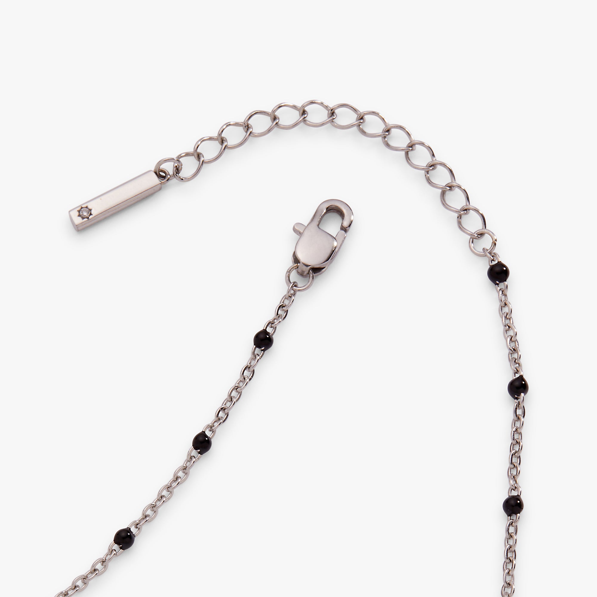 Silver chain necklace with black beads on a white background