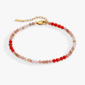 Beaded bracelet with red and pink stones on a white background