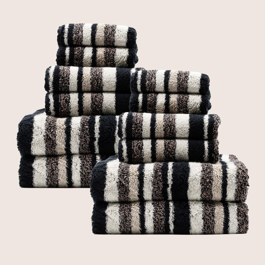 Set of striped towels in black, white, and gray on a beige background