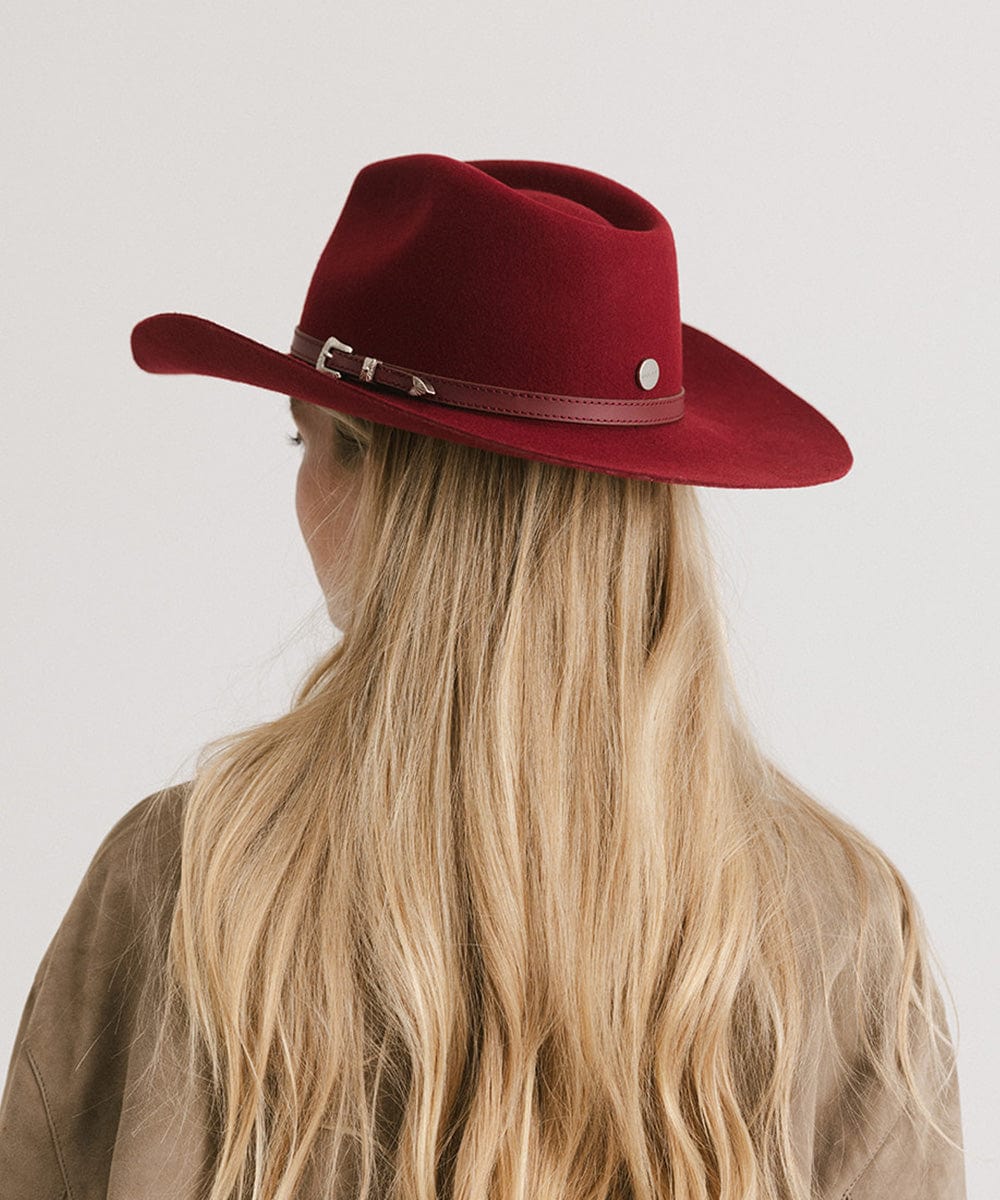 Person wearing a red cowboy hat with a white background