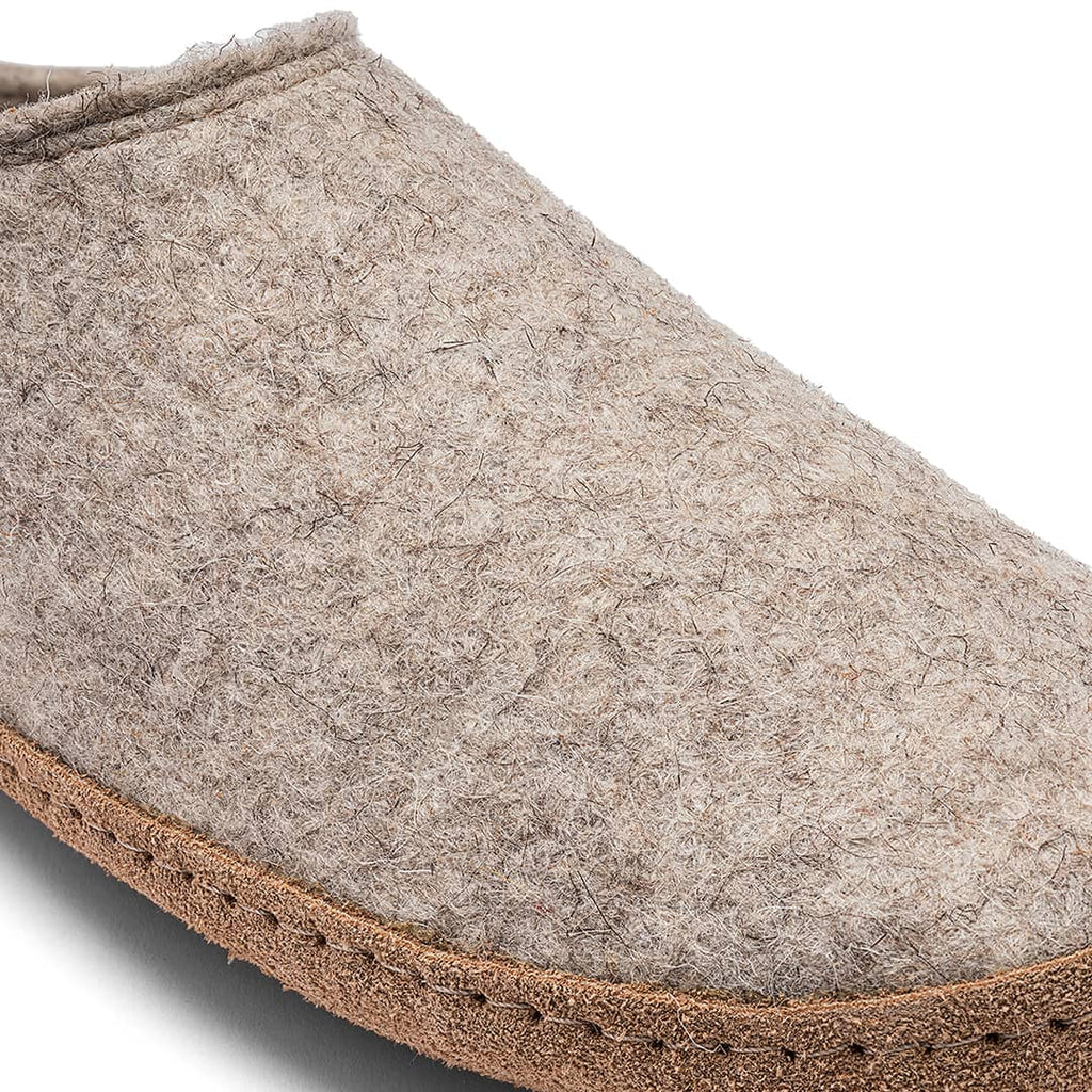 Close-up of a gray felt slipper with brown trim on a white background