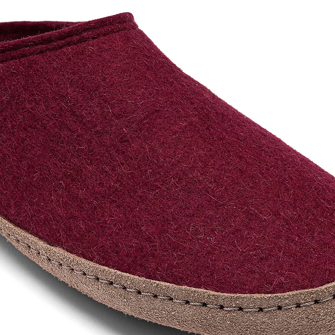 Close-up of a maroon slipper with a brown sole on a white background