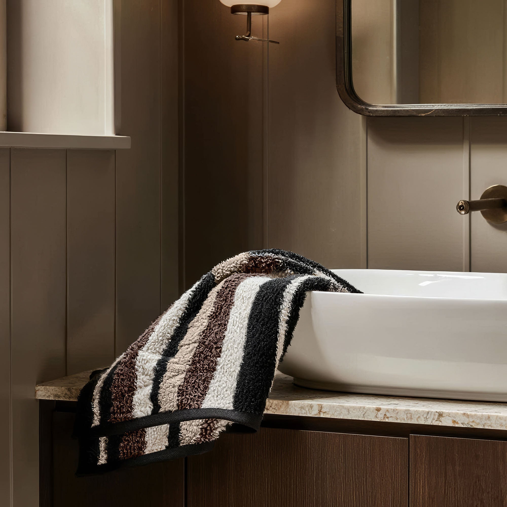 Striped towel draped over a sink in a bathroom setting