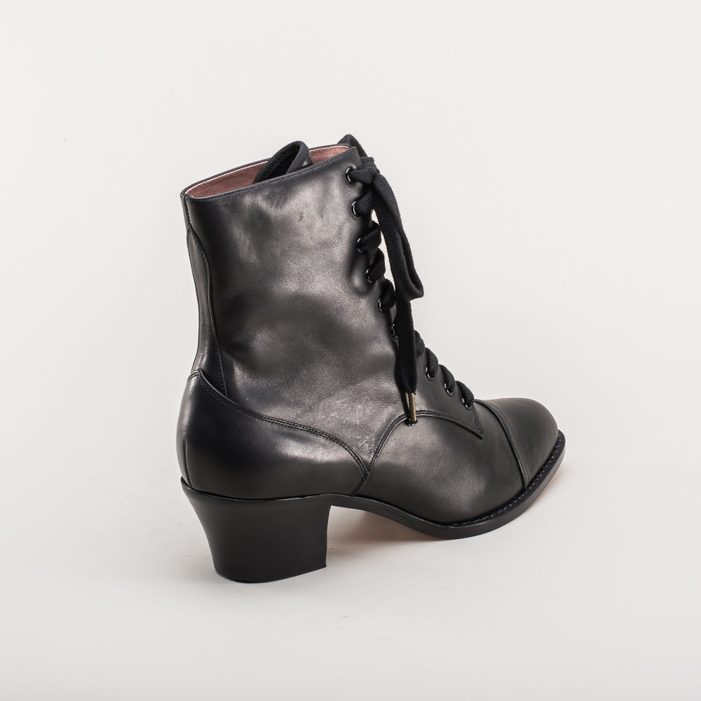 Black leather boot with lace-up design on a white background