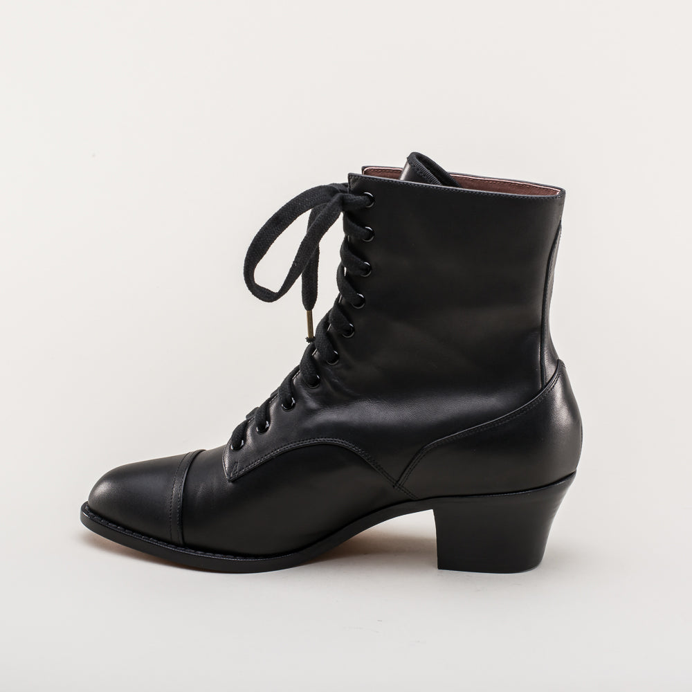 Black leather lace-up boot on a light gray background