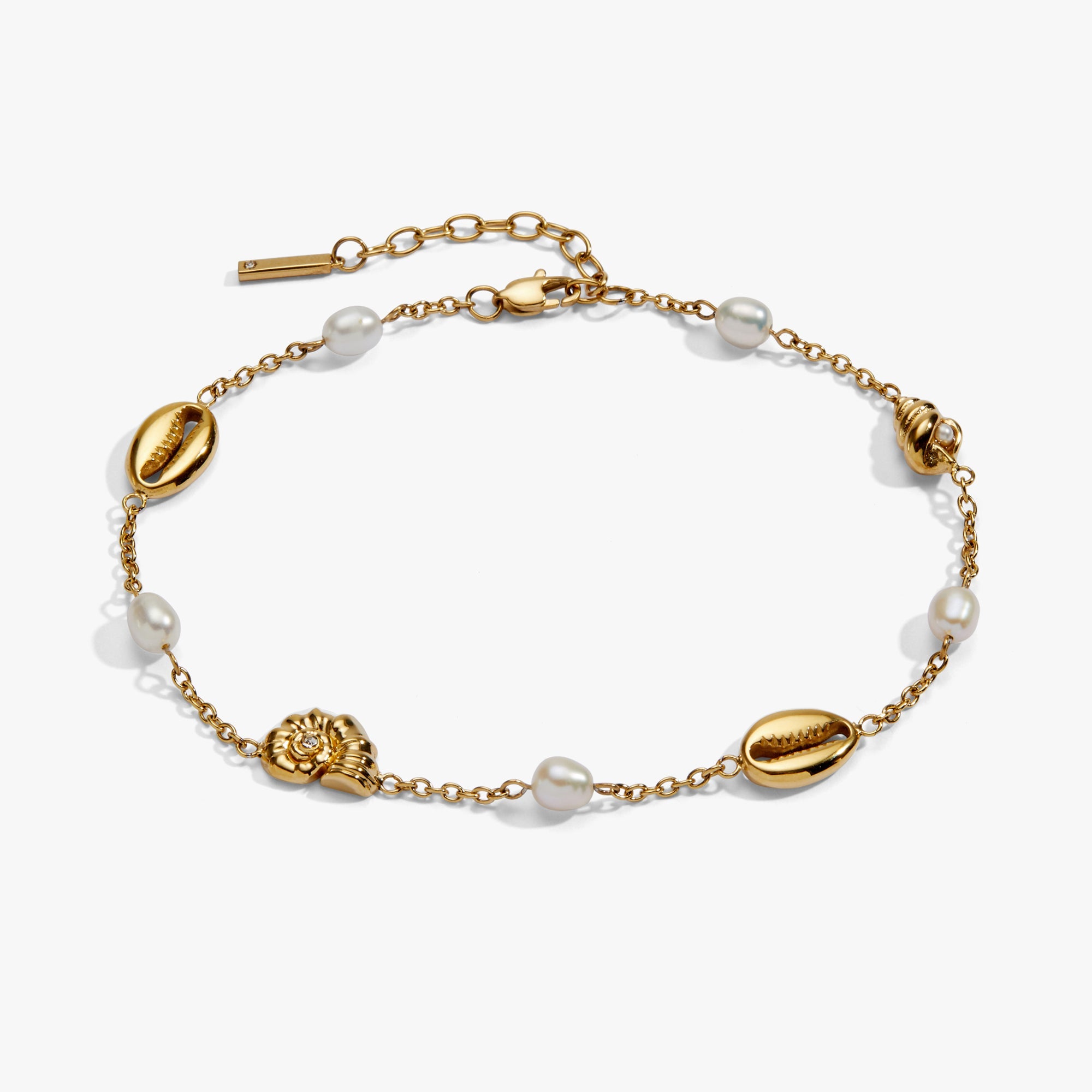 Gold bracelet with pearls and shell-shaped beads on a white background