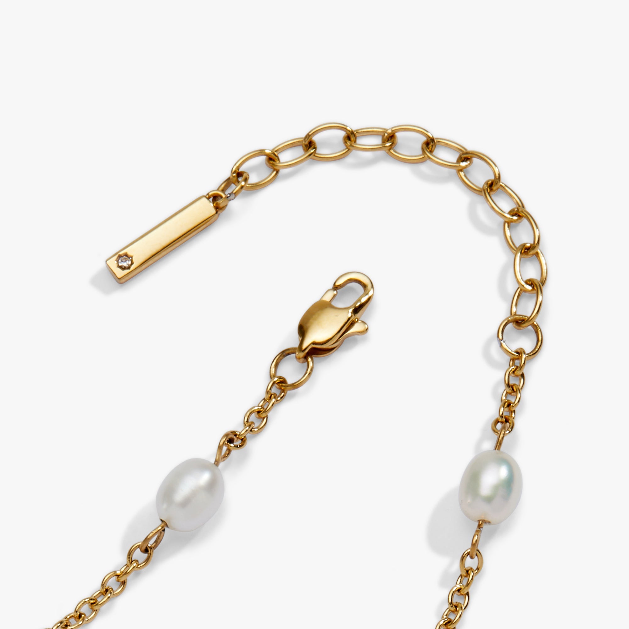 Gold chain bracelet with pearls on a white background