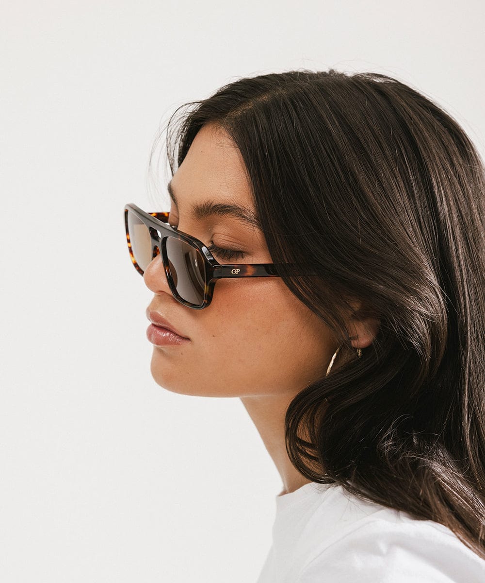 Woman wearing sunglasses with a plain background