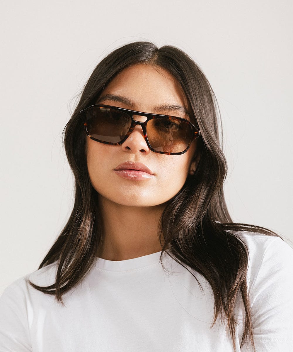 Woman wearing sunglasses with a plain background