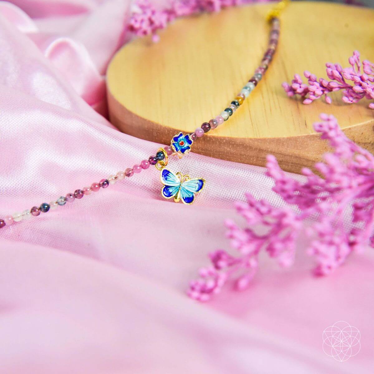 Necklace with a butterfly pendant on a pink fabric background